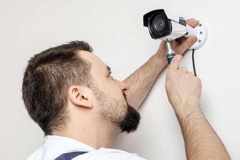Technicien vérifiant une caméra de vidéosurveillance